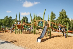 Schulhof mit abwechslungsreichen Spielgeräten aus Holz